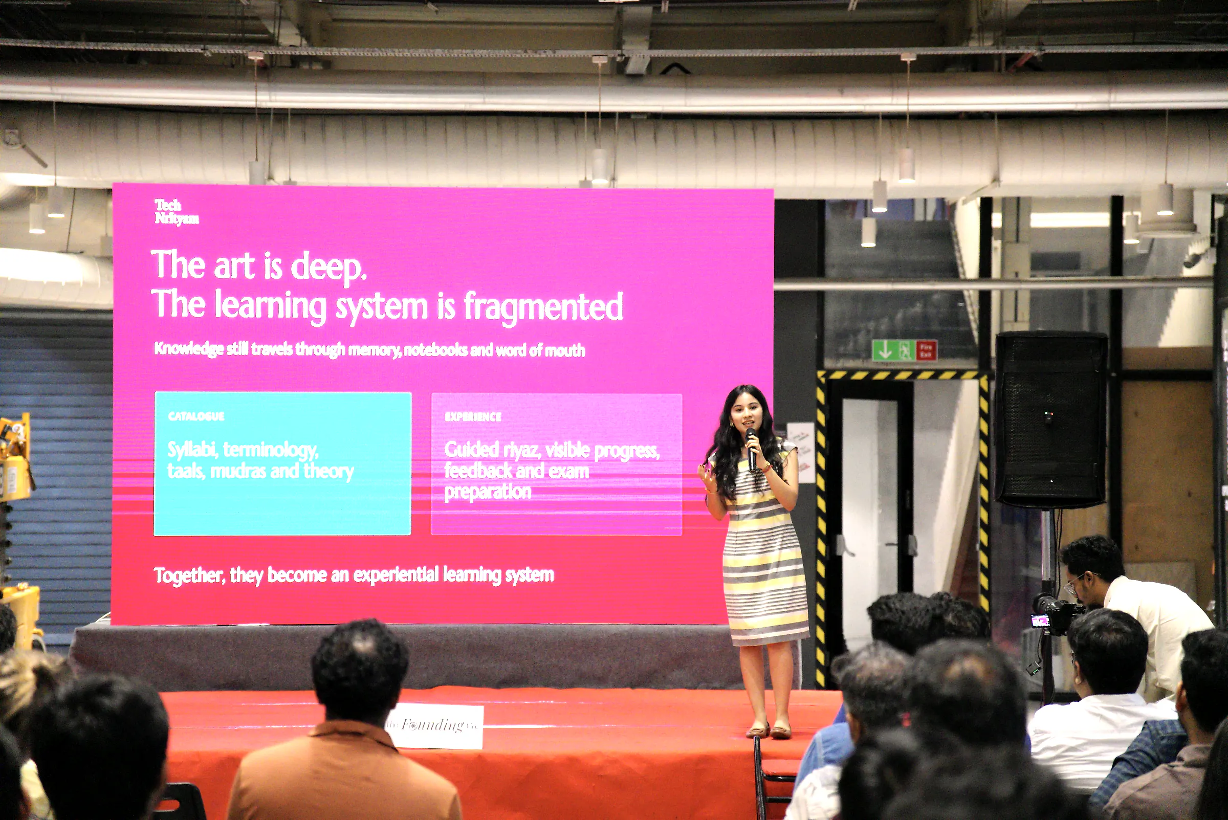 A founder presenting her company on stage at Demo Day