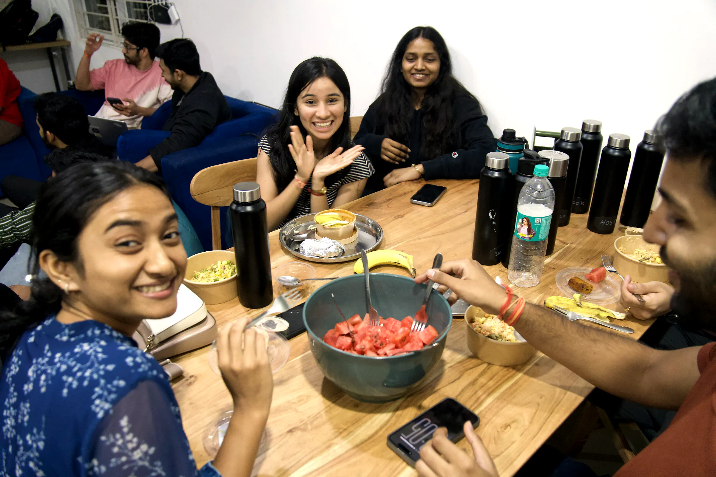 Founders laughing around the dining table over a bowl of watermelon